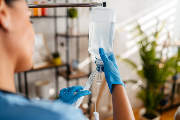 home care nurse adjusting and preparing an iv drip inside an apartment,